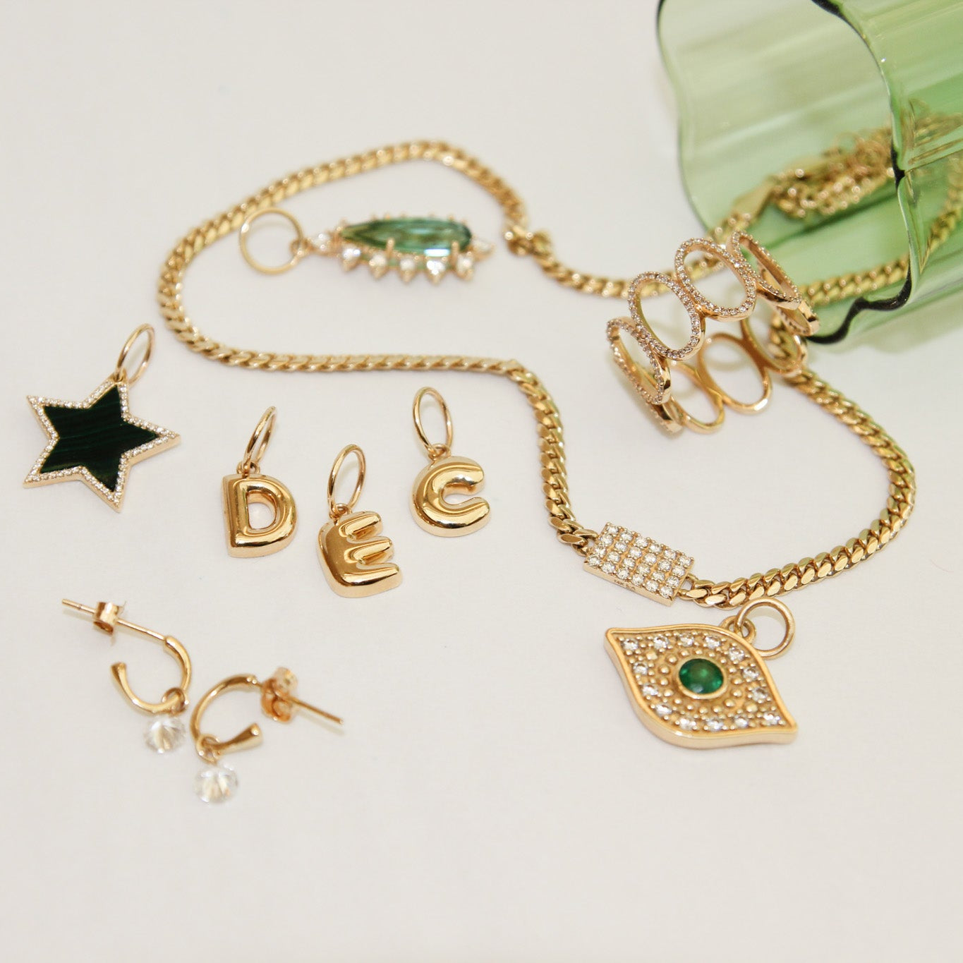 Gold jewelry set with various pieces including a bracelet, earrings, and pendants on a light background.