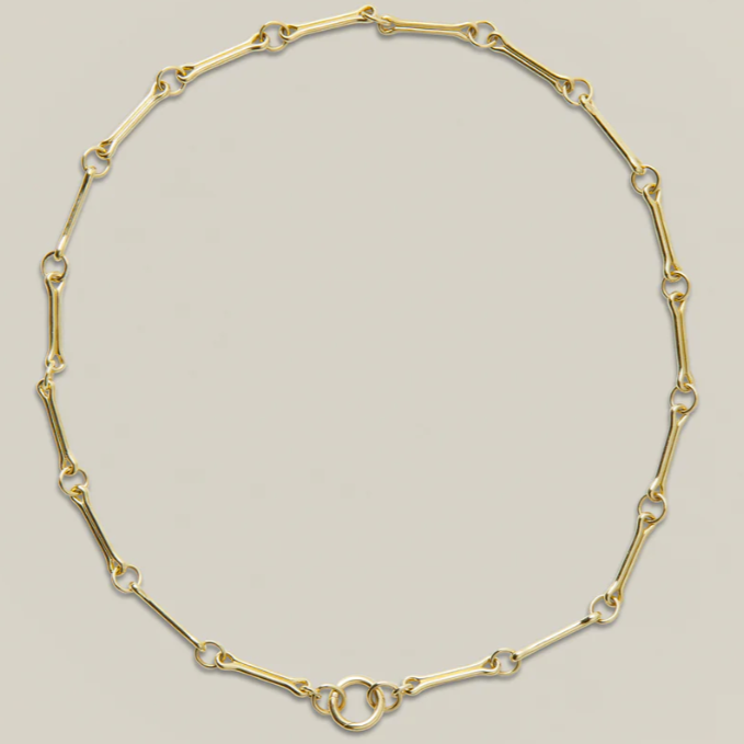 Gold chain necklace on a light gray background