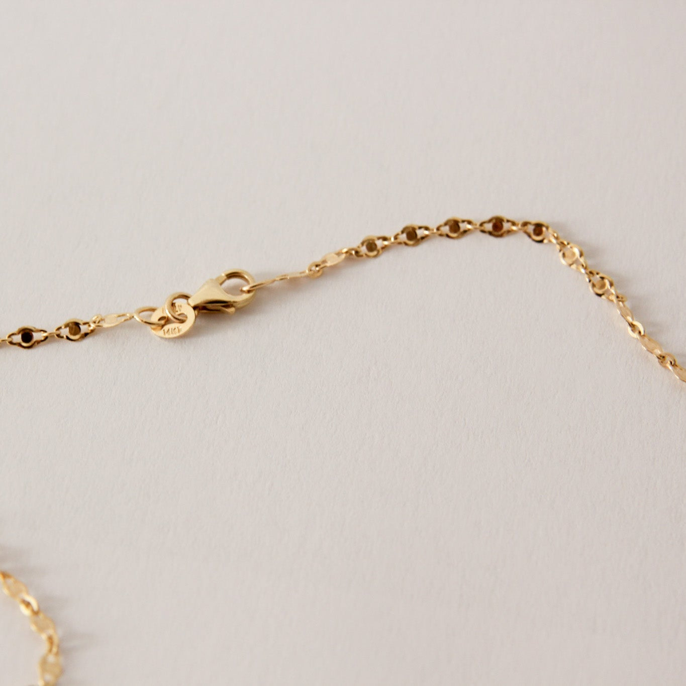 Gold chain on a light gray background