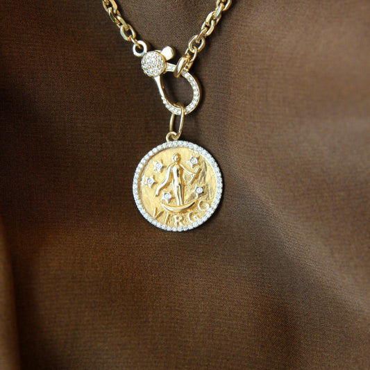 Gold necklace with a circular pendant on a brown background