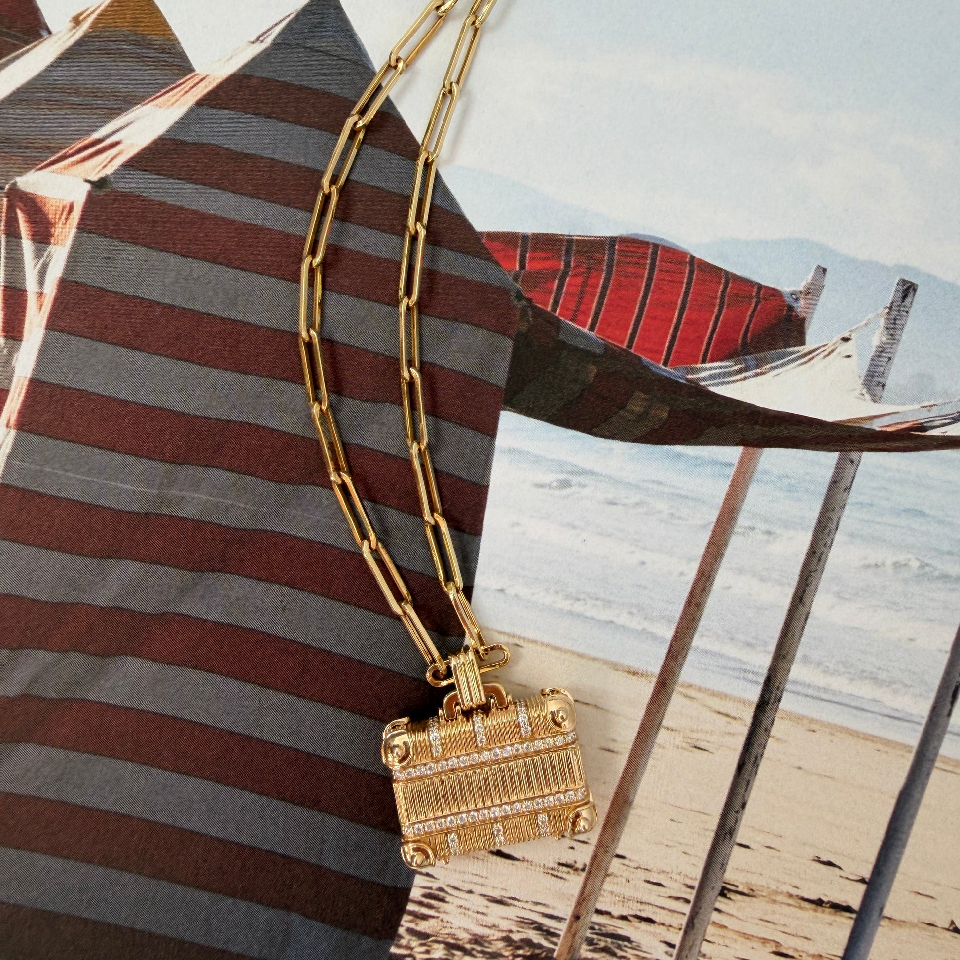 Striped handbag with gold chain detail on a textured surface
