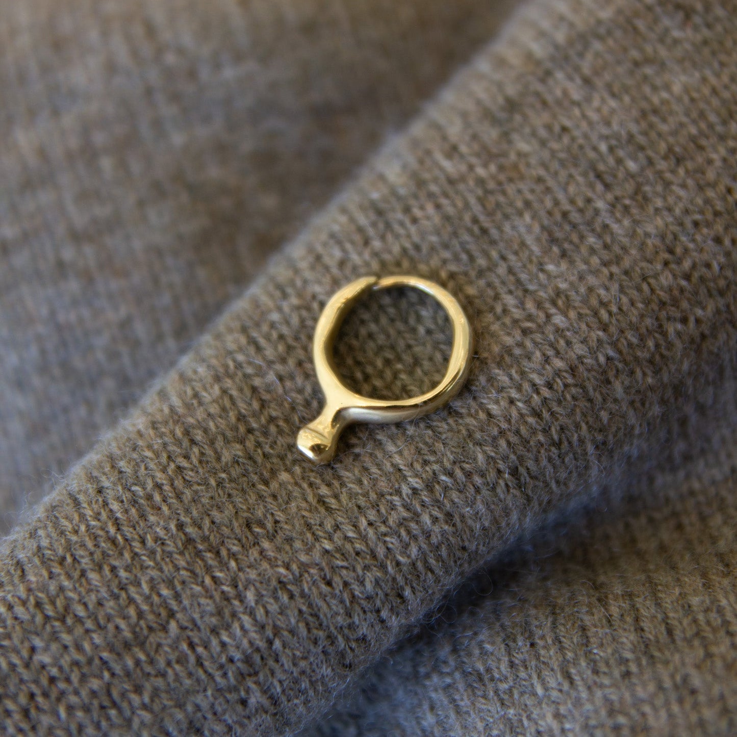 Gold ring on a textured gray fabric background
