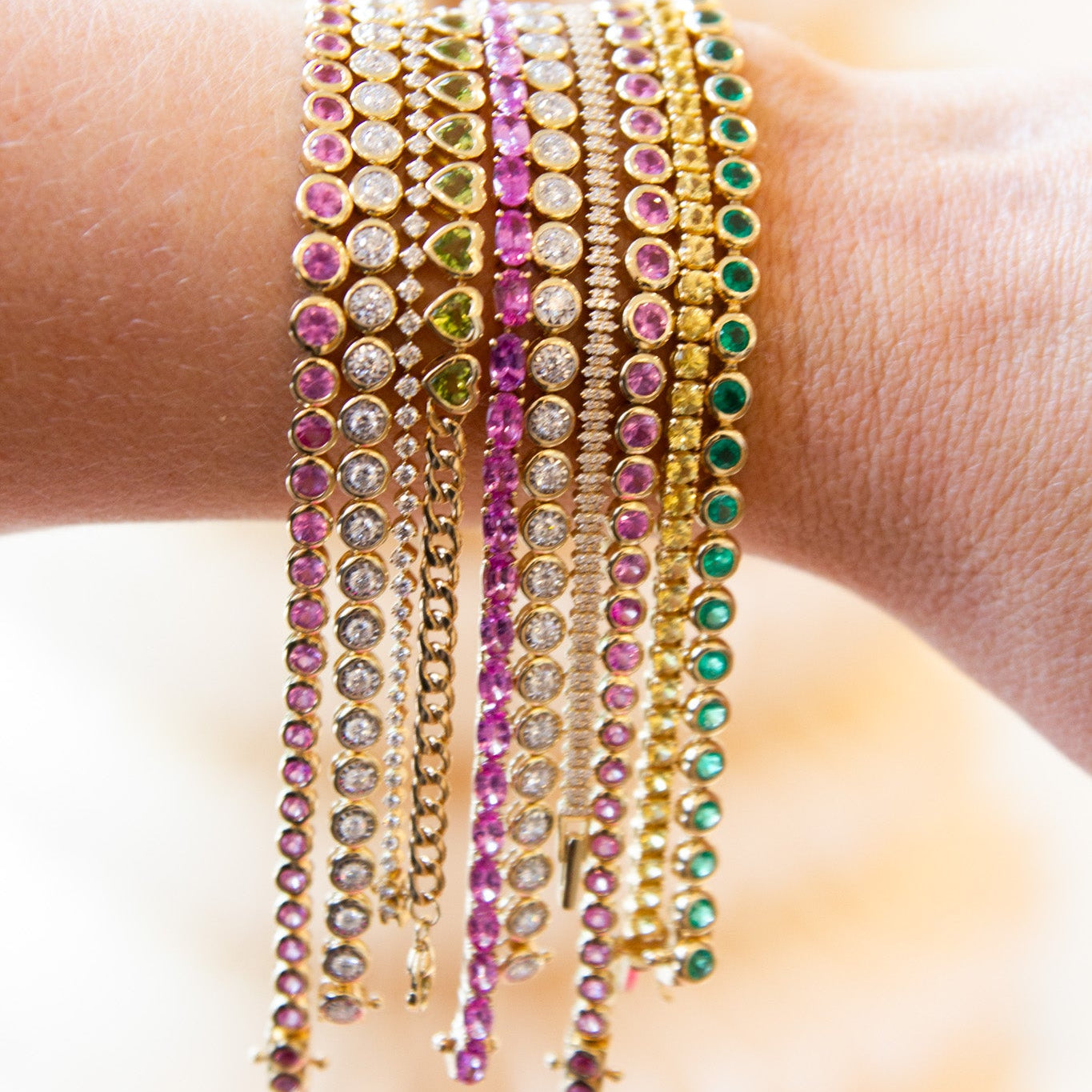 Multiple colorful beaded bracelets on a wrist with a blurred background