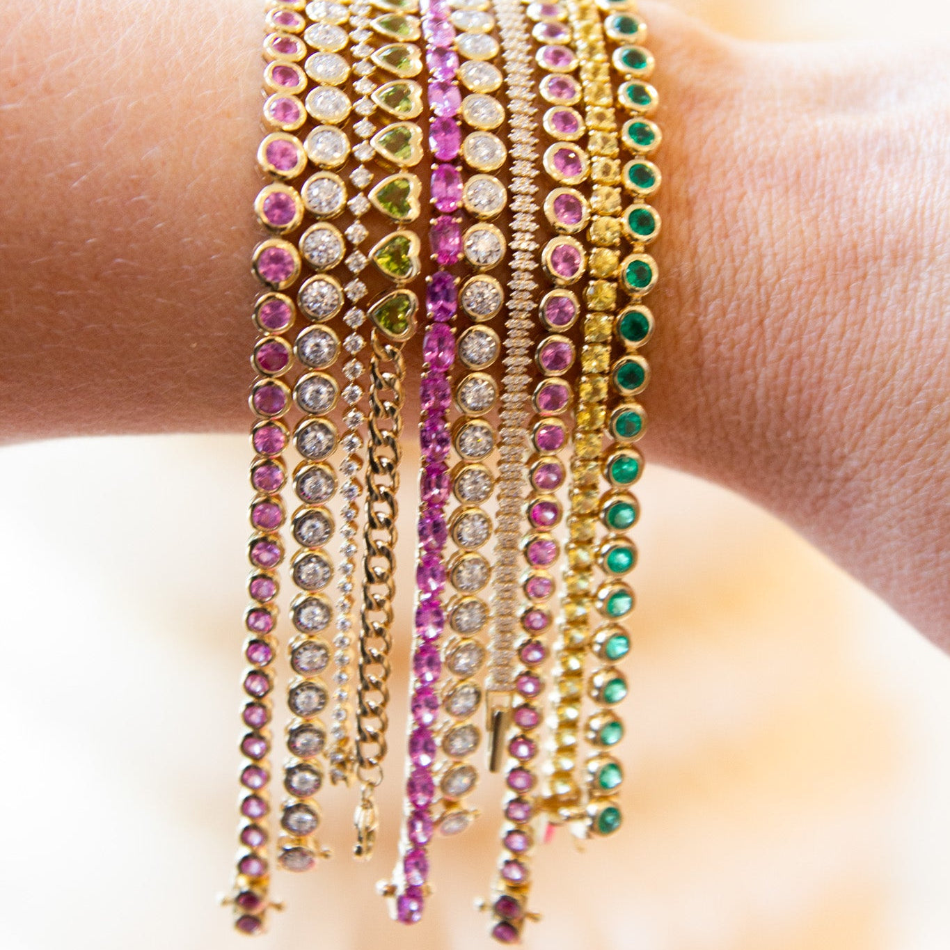 Multiple colorful bracelets on a wrist with a blurred background