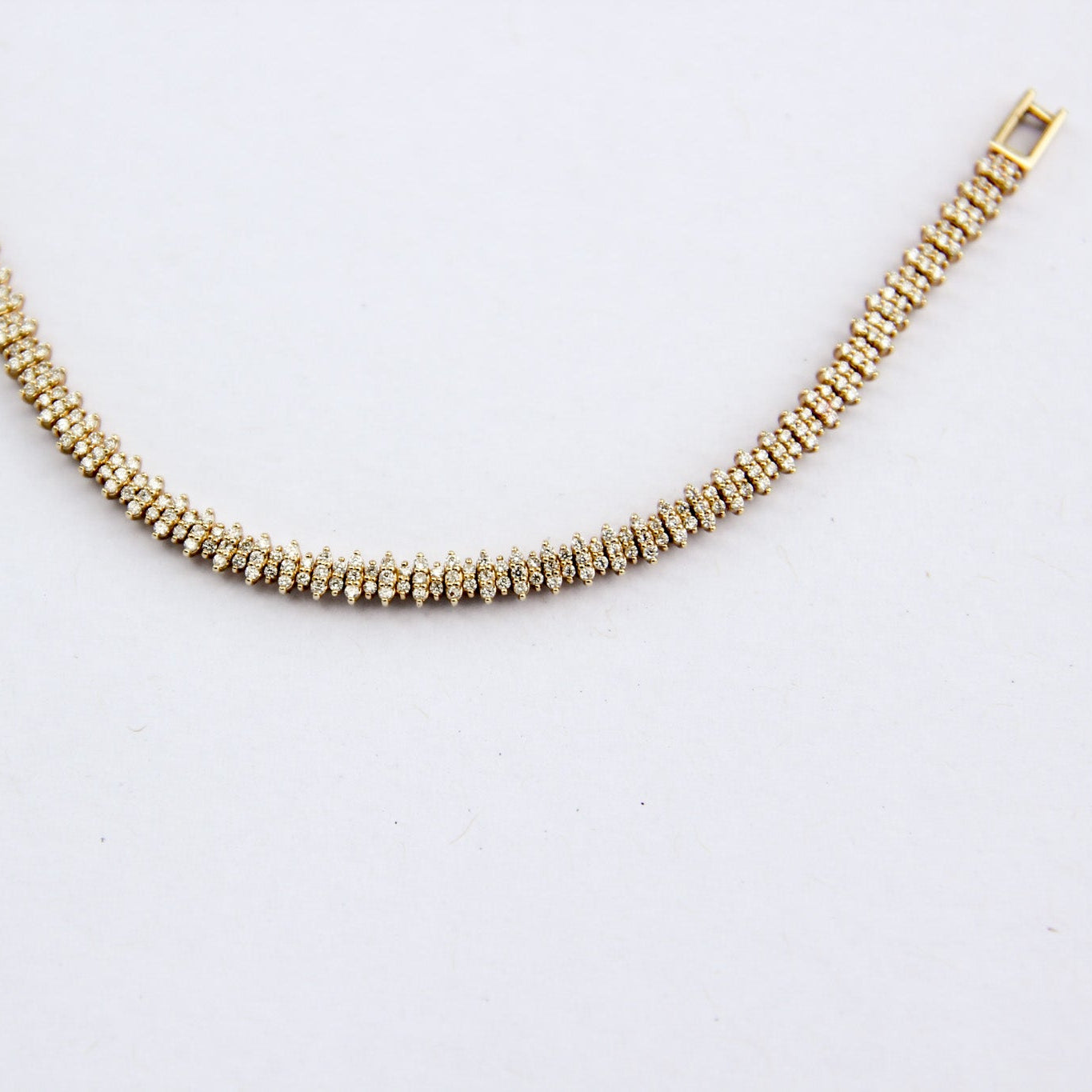 Gold bracelet on a light gray background