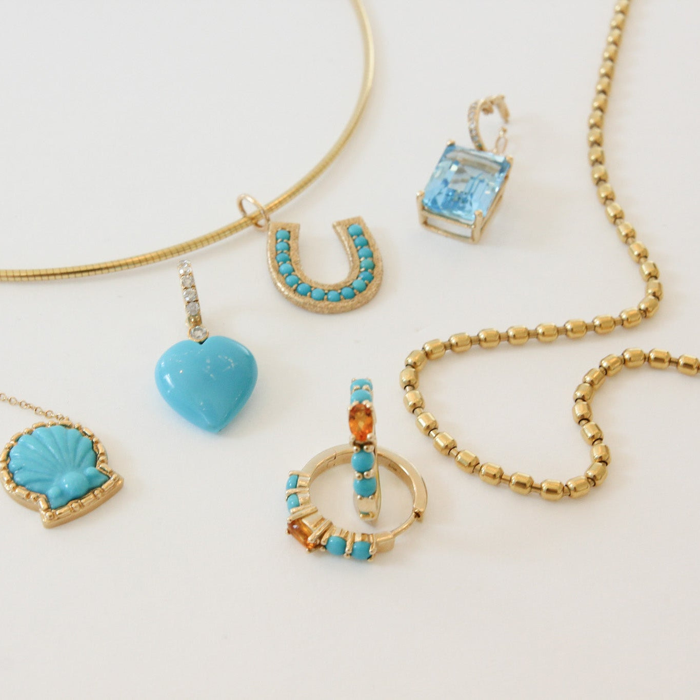 Collection of gold and turquoise necklaces on a light background