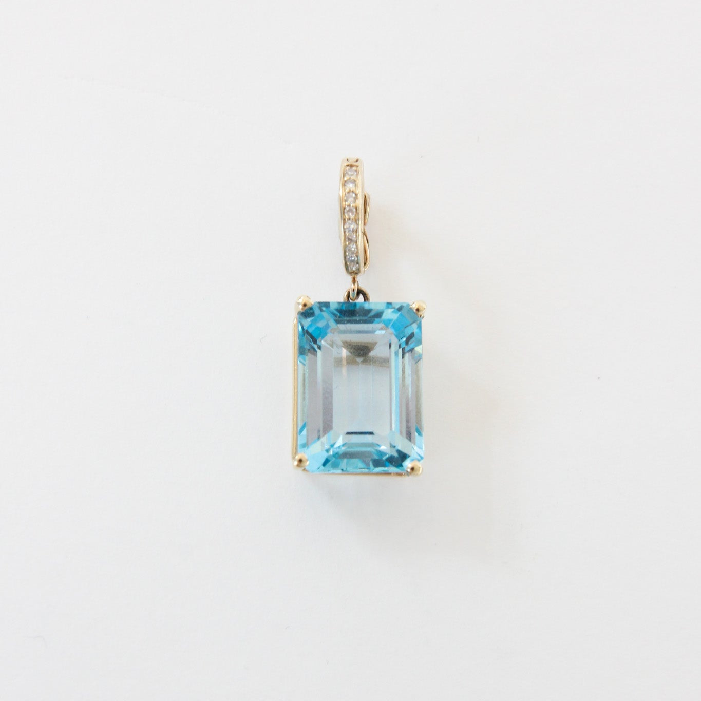 Diamond pendant with a blue gemstone on a white background