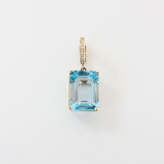 Diamond pendant with a blue gemstone on a white background