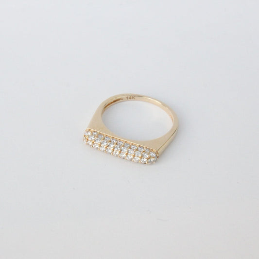 Gold ring with diamonds on a light gray background