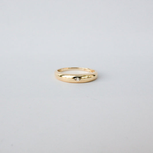 Gold ring on a light gray background