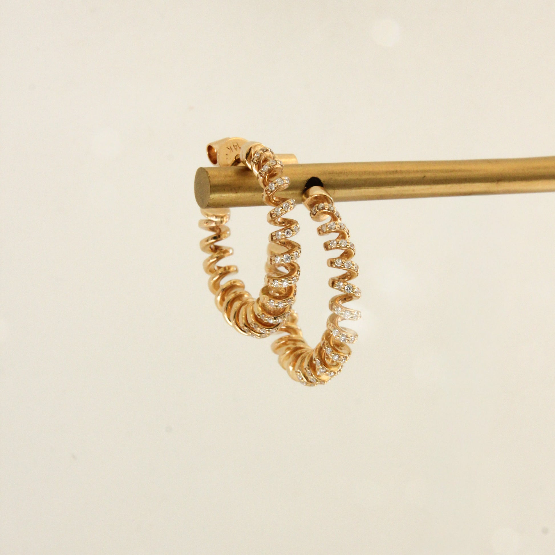 Gold hoop earrings on a beige background