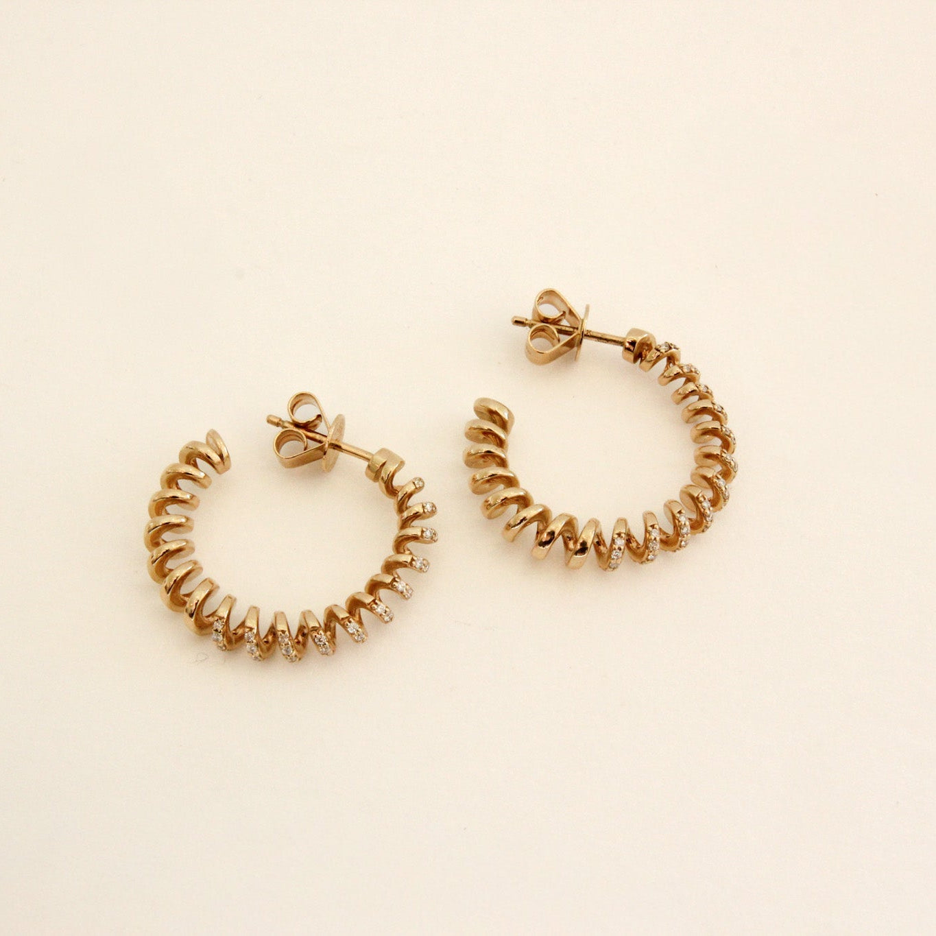 Gold hoop earrings on a beige background
