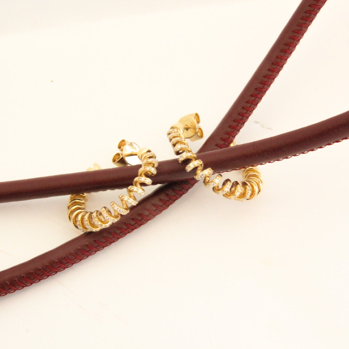 Gold spiral hair ties on brown hair ties against a white background