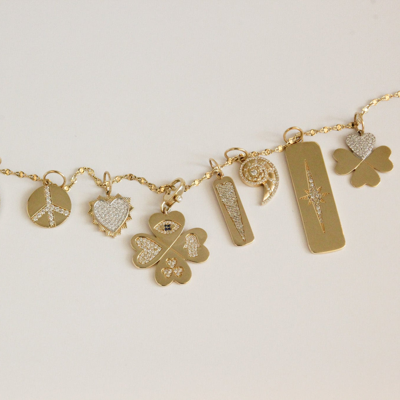Gold necklace with various charms on a light background