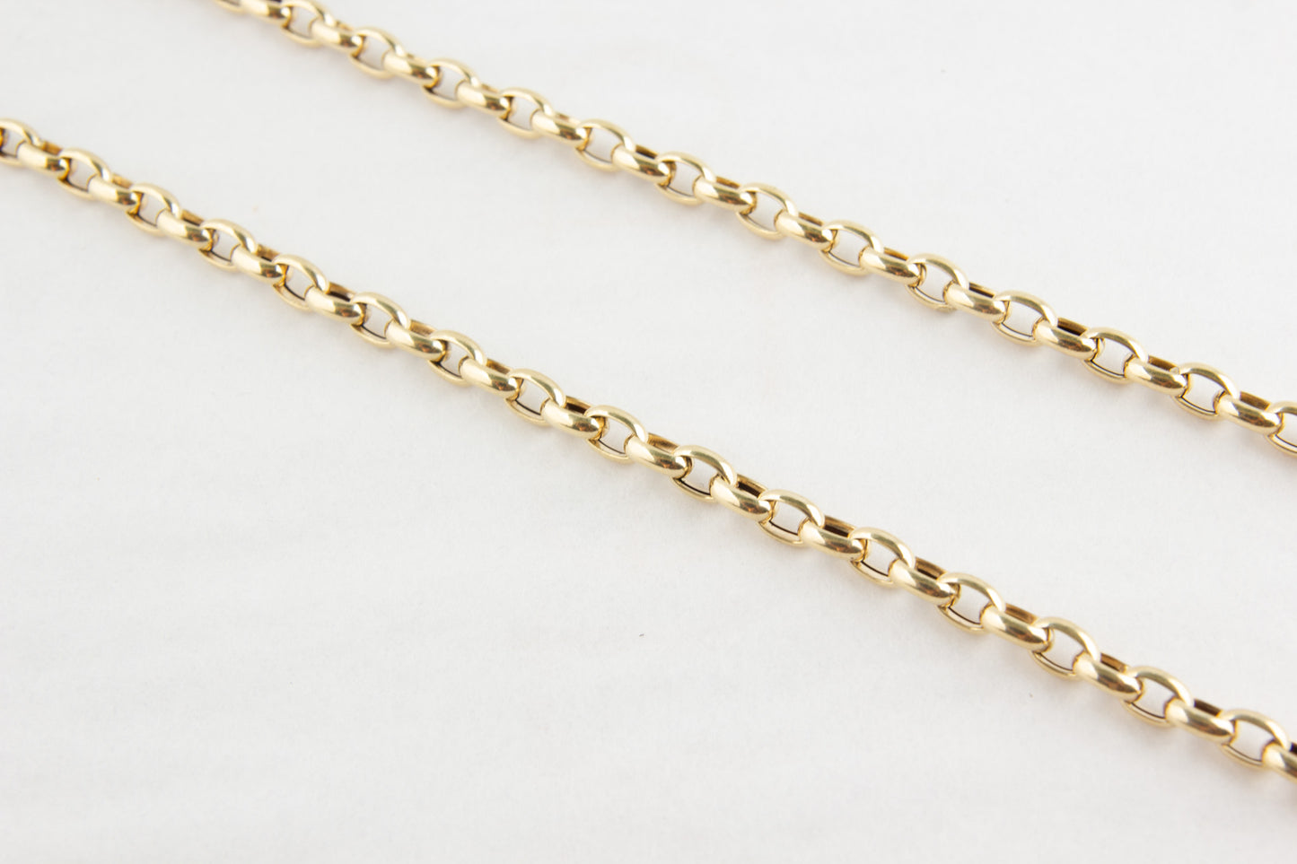 Gold chain on a light gray background