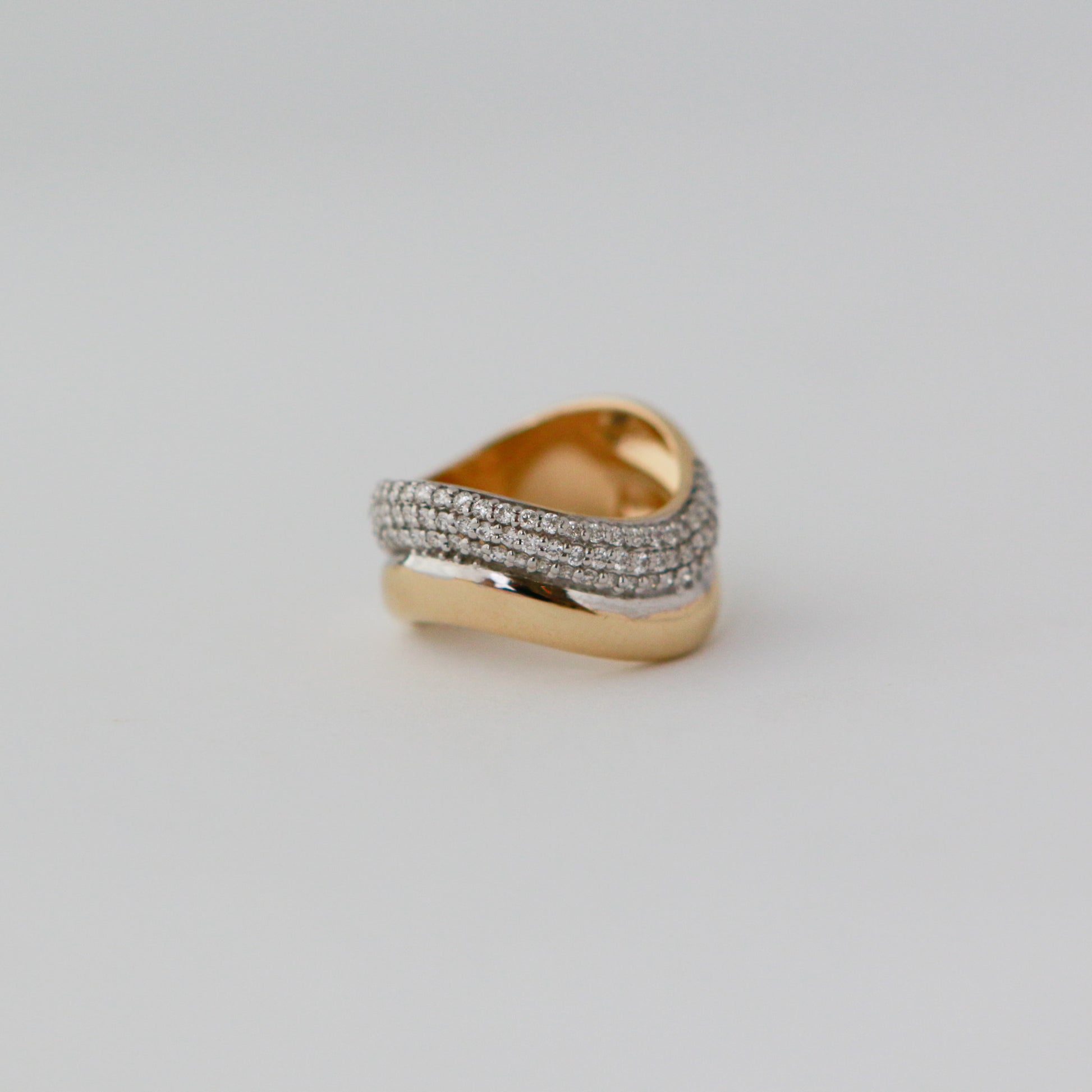 Gold and silver ring on a light gray background