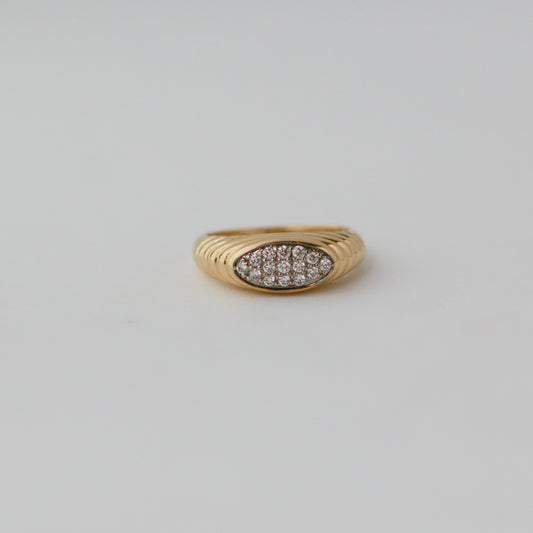 Gold ring with diamond pavé on a light gray background