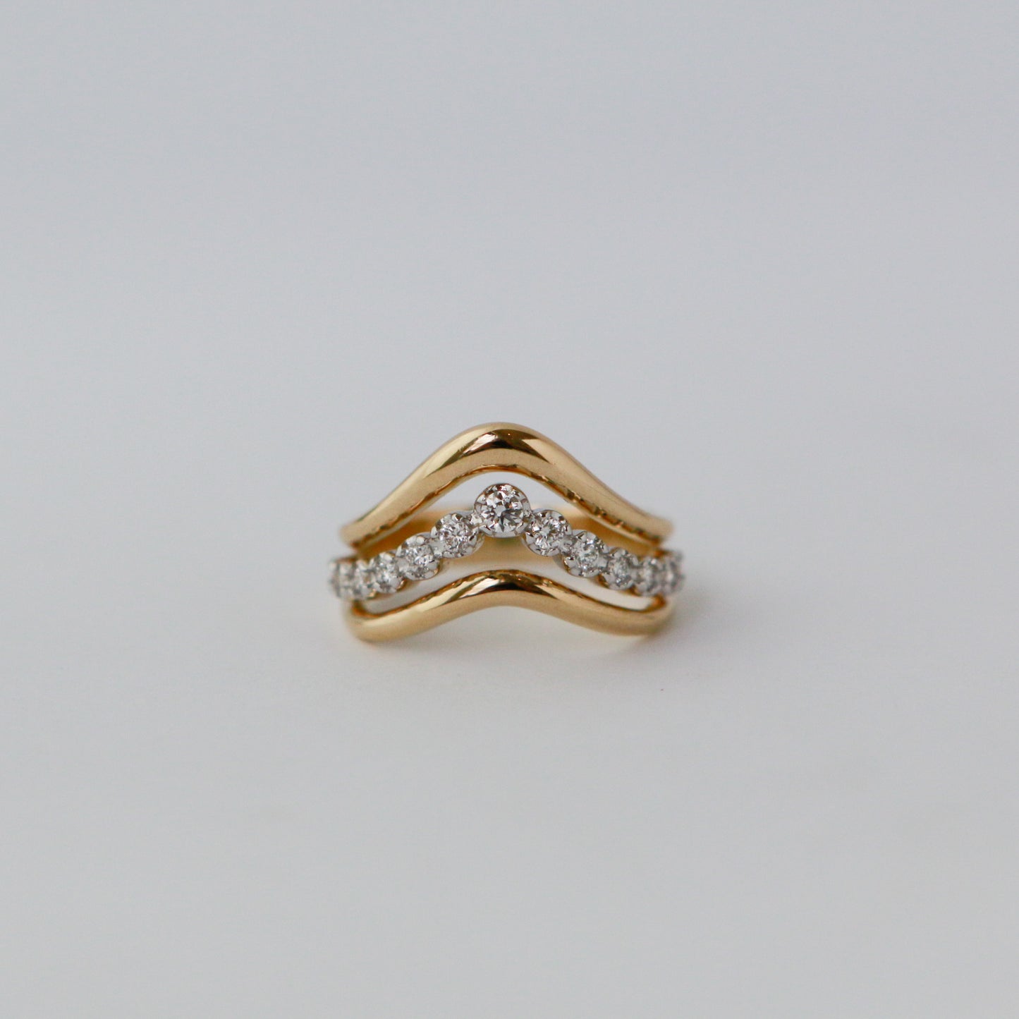 Gold ring with diamond accents on a light gray background