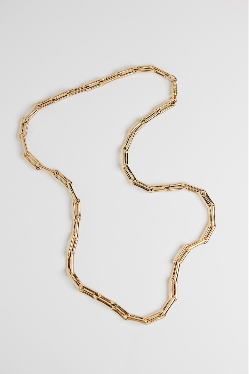 Gold chain necklace on a light gray background